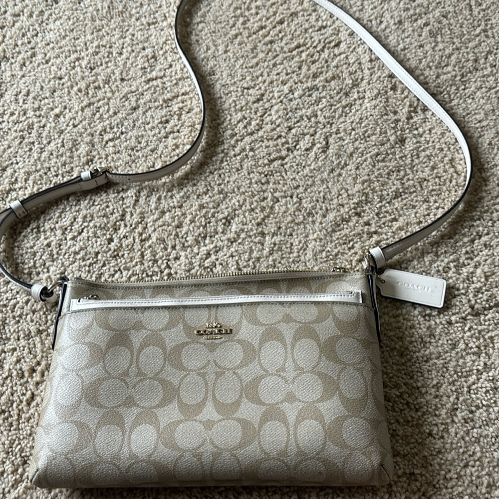 Selling a pretty much brand new coach purse. Cream/tan color. Has 4 pockets.